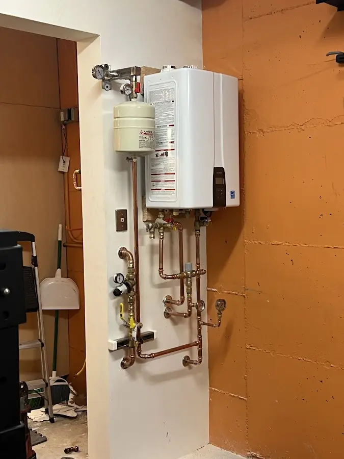 Plumbing technician inspecting water heater connections in Raleigh